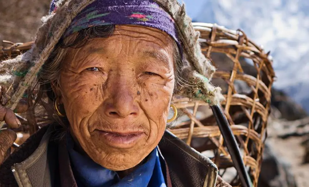Nepalese woman carrying basket in mountains