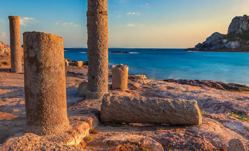 Ancient ruins in Greece overlooking deep blue sea